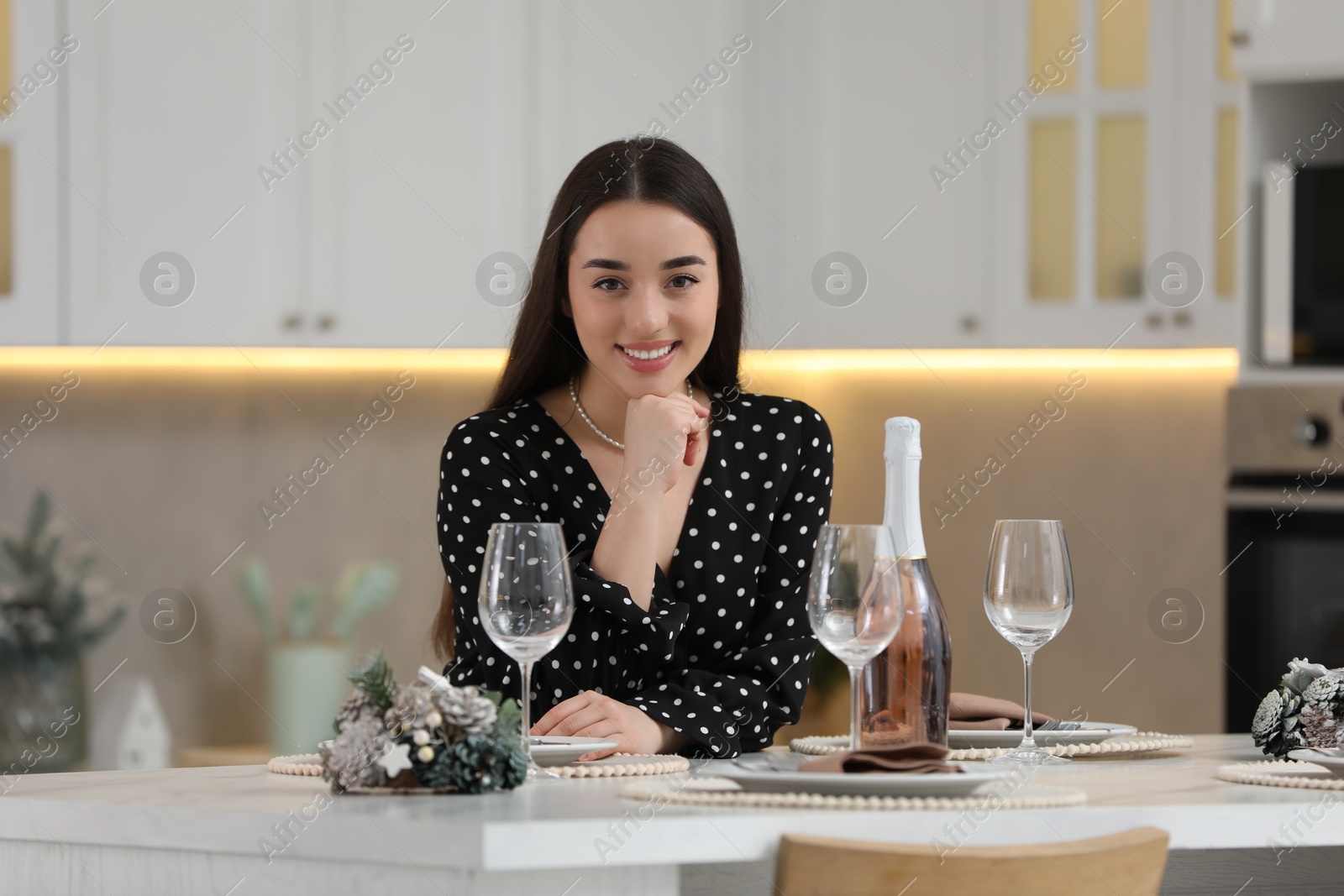 Photo of Christmas mood. Portrait of smiling woman at table in kitchen