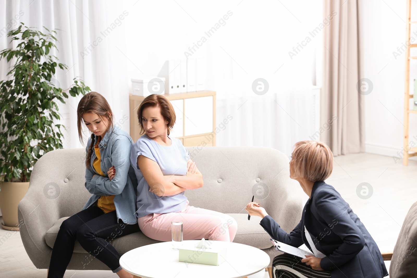 Photo of Psychotherapist working with teenage girl and her mother in office