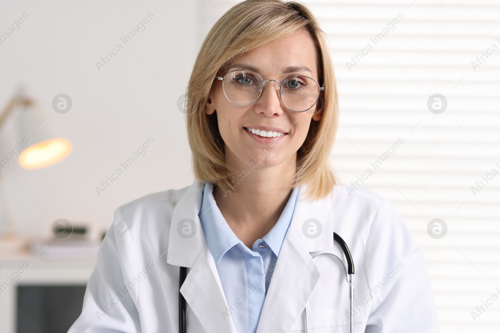 Photo of Portrait of smiling doctor on blurred background