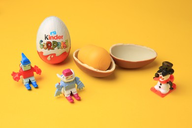 Photo of Sveti Vlas, Bulgaria - June 29, 2023: Kinder Surprise Eggs and toys on orange background