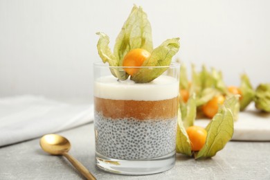 Photo of Delicious chia pudding decorated with physalis on light grey table