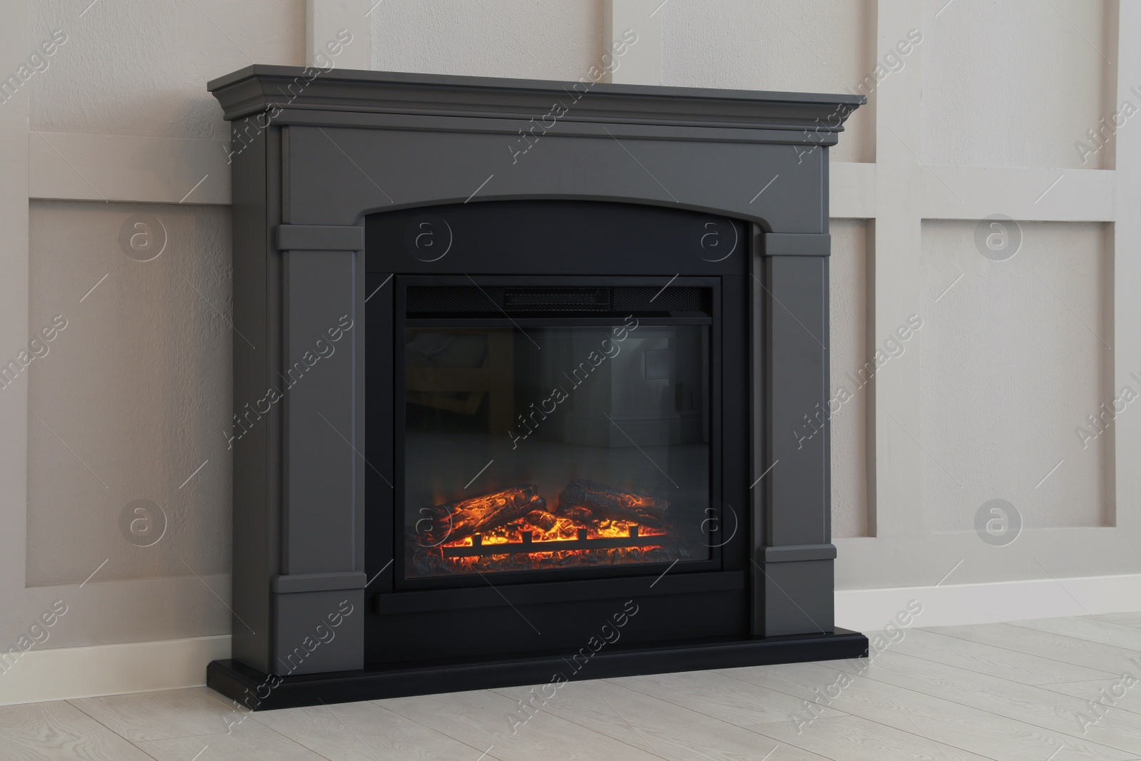 Photo of Modern electric fireplace near light wall indoors