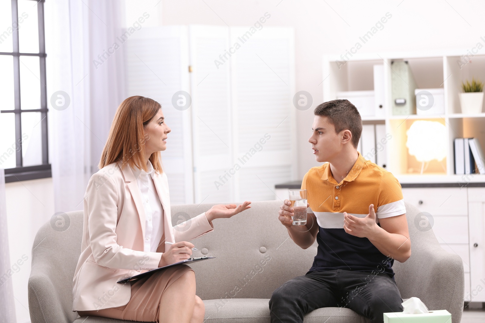 Photo of Psychotherapist working with young man in office