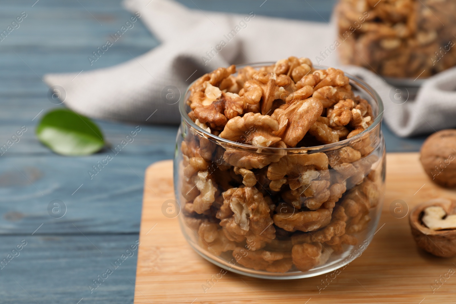 Photo of Tasty walnuts in glass jar on table