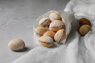 Photo of Delicious walnut shaped cookies with condensed milk on grey table, closeup