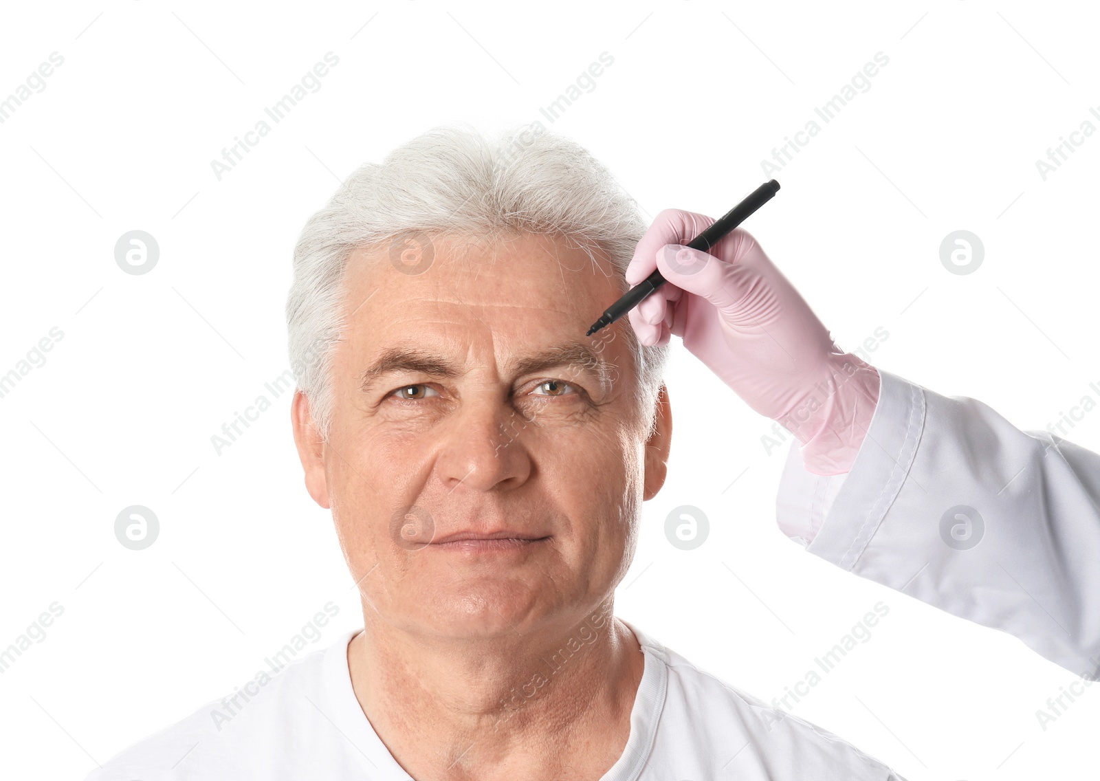 Photo of Doctor drawing marks on mature man's face for cosmetic surgery operation against white background