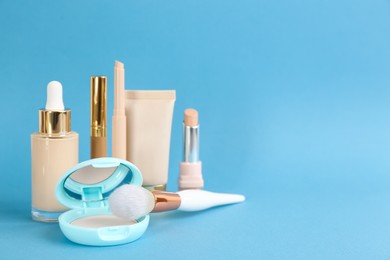 Photo of Foundation makeup products on light blue background, space for text. Decorative cosmetics