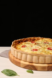 Photo of Delicious homemade cheese quiche on white table against black background