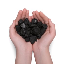 Woman with handful of coal on white background, top view