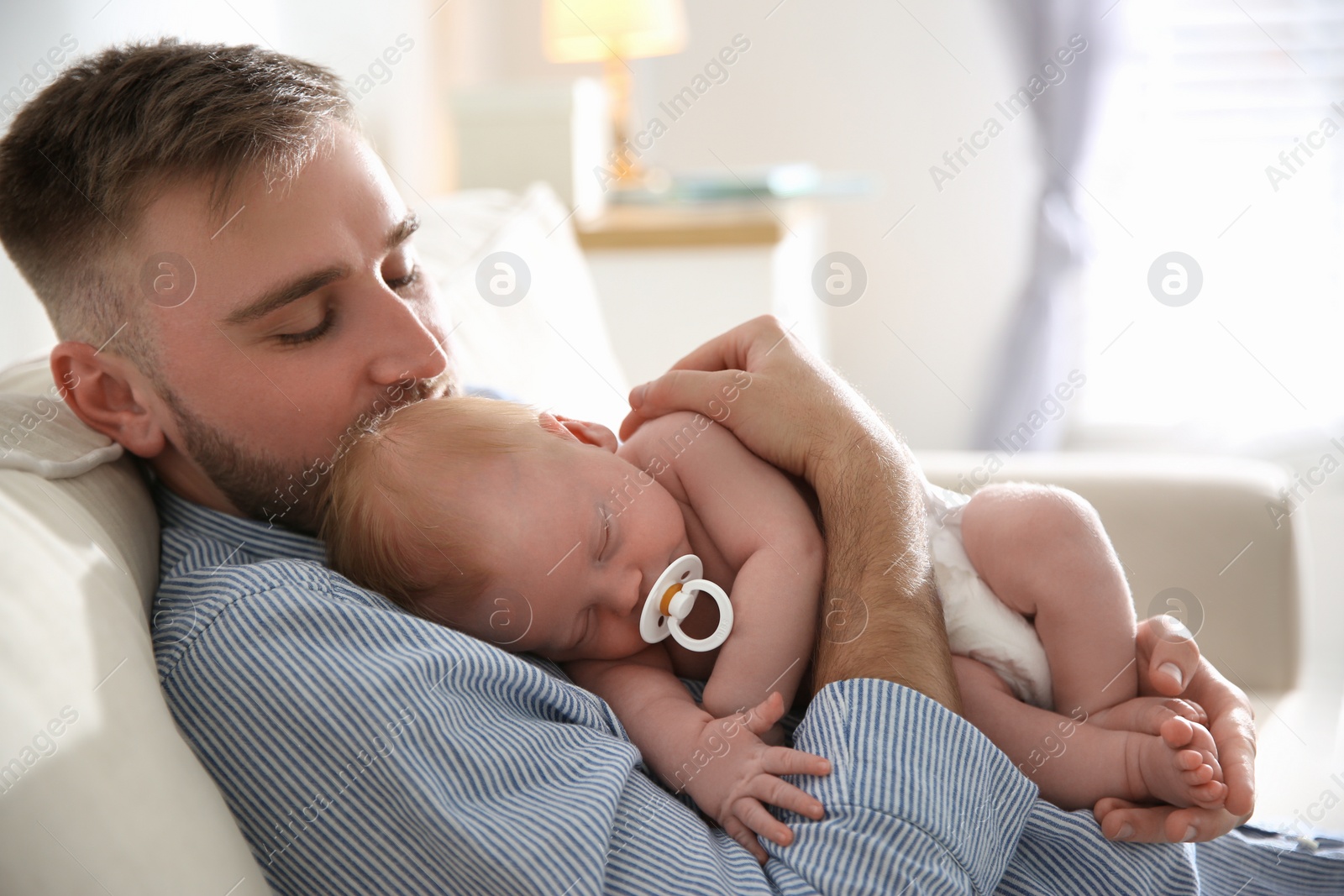 Photo of Father with his newborn son at home