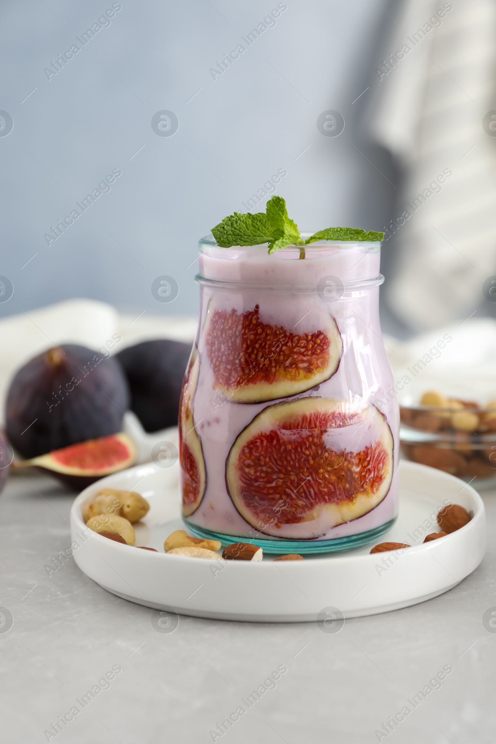 Photo of Delicious fig smoothie in glass jar on light table