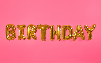 Photo of Word BIRTHDAY made of foil balloon letters on pink background