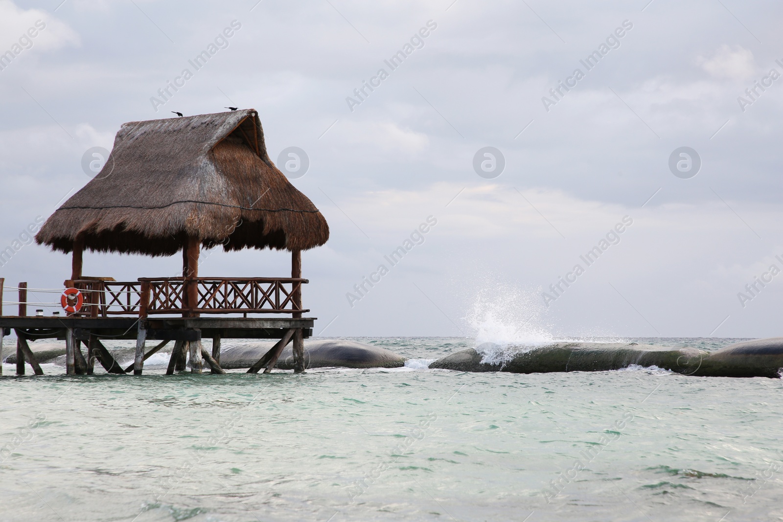 Photo of Wooden gazebo in sea on stormy weather