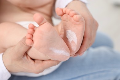 Photo of Mother holding baby`s feet on bed, closeup