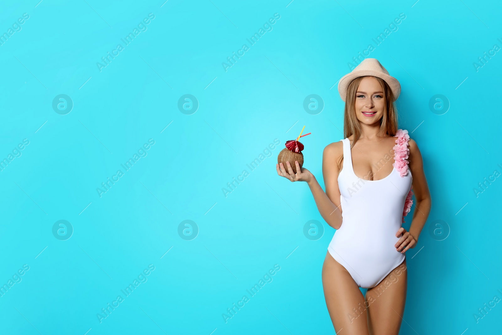 Photo of Sexy young woman in bikini with coconut cocktail on color background