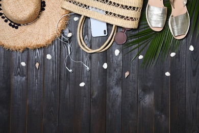 Photo of Flat lay composition with stylish beach accessories on black wooden table. Space for text