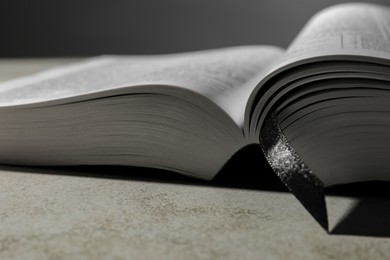 Open Bible on light gray table, closeup. Christian religious book