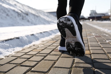 Man running outdoors on winter day, closeup. Sports exercises