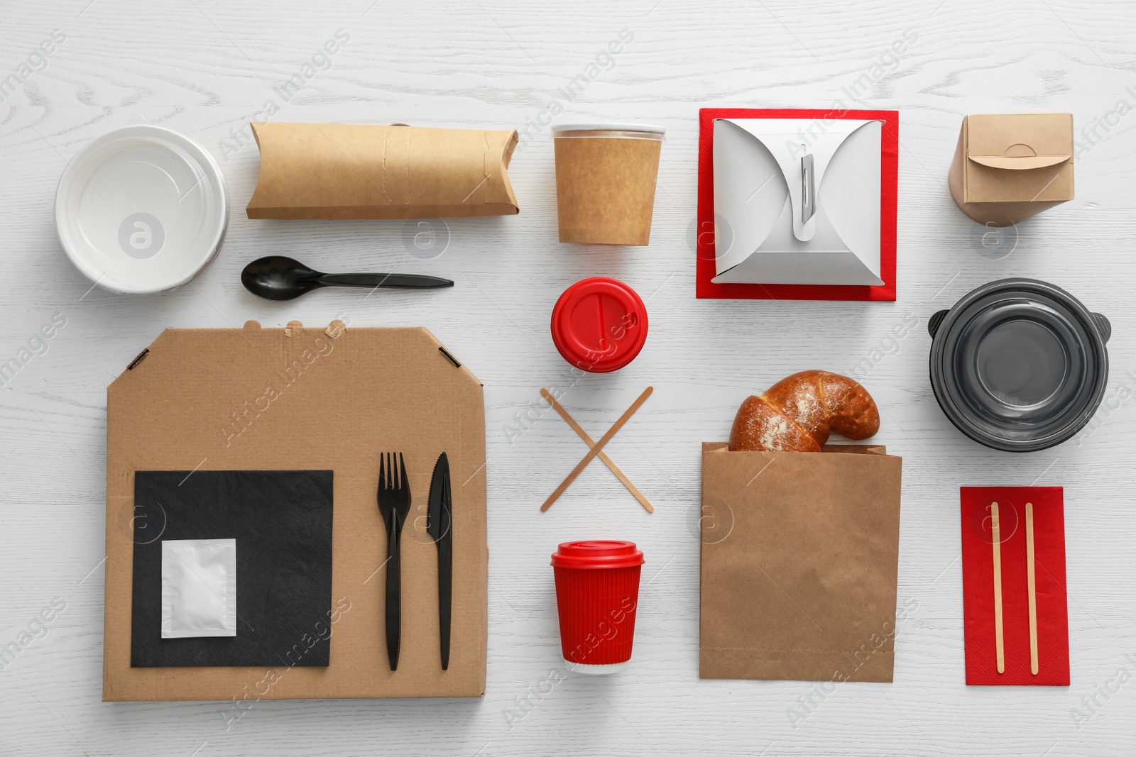 Photo of Flat lay composition with paper bag and different takeaway items on wooden background. Space for design