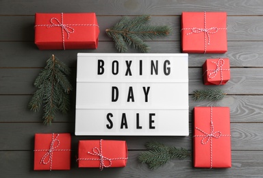 Flat lay composition with Boxing Day Sale sign and Christmas gifts on grey wooden table
