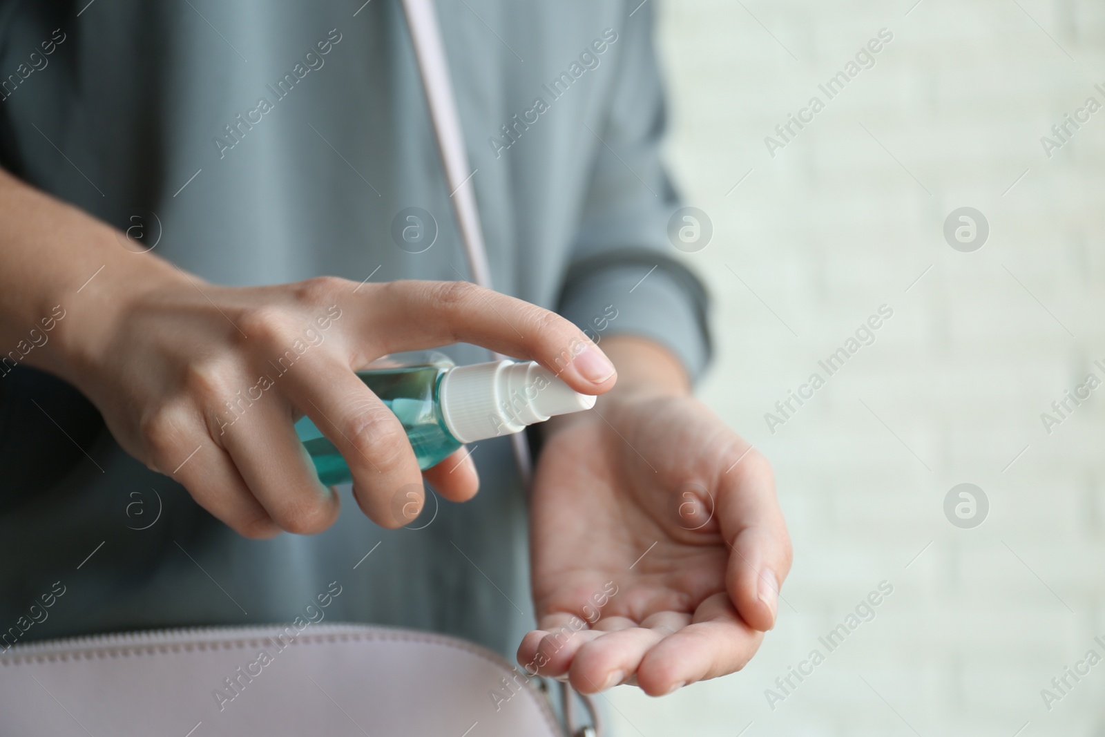 Photo of Woman applying hand sanitizer on light background, closeup. Personal hygiene during COVID-19 pandemic
