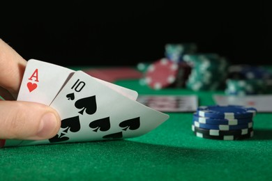 Photo of Man playing poker at table with casino chips, closeup. Space for text