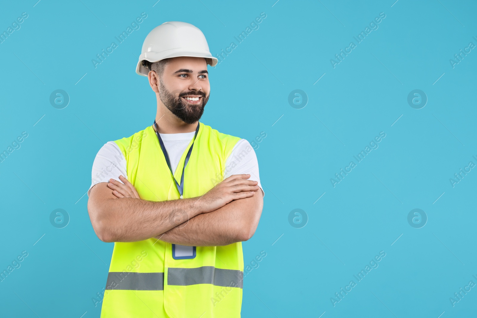 Photo of Engineer with hard hat and badge on light blue background, space for text