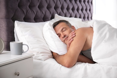 Photo of Man sleeping on comfortable pillow in bed at home