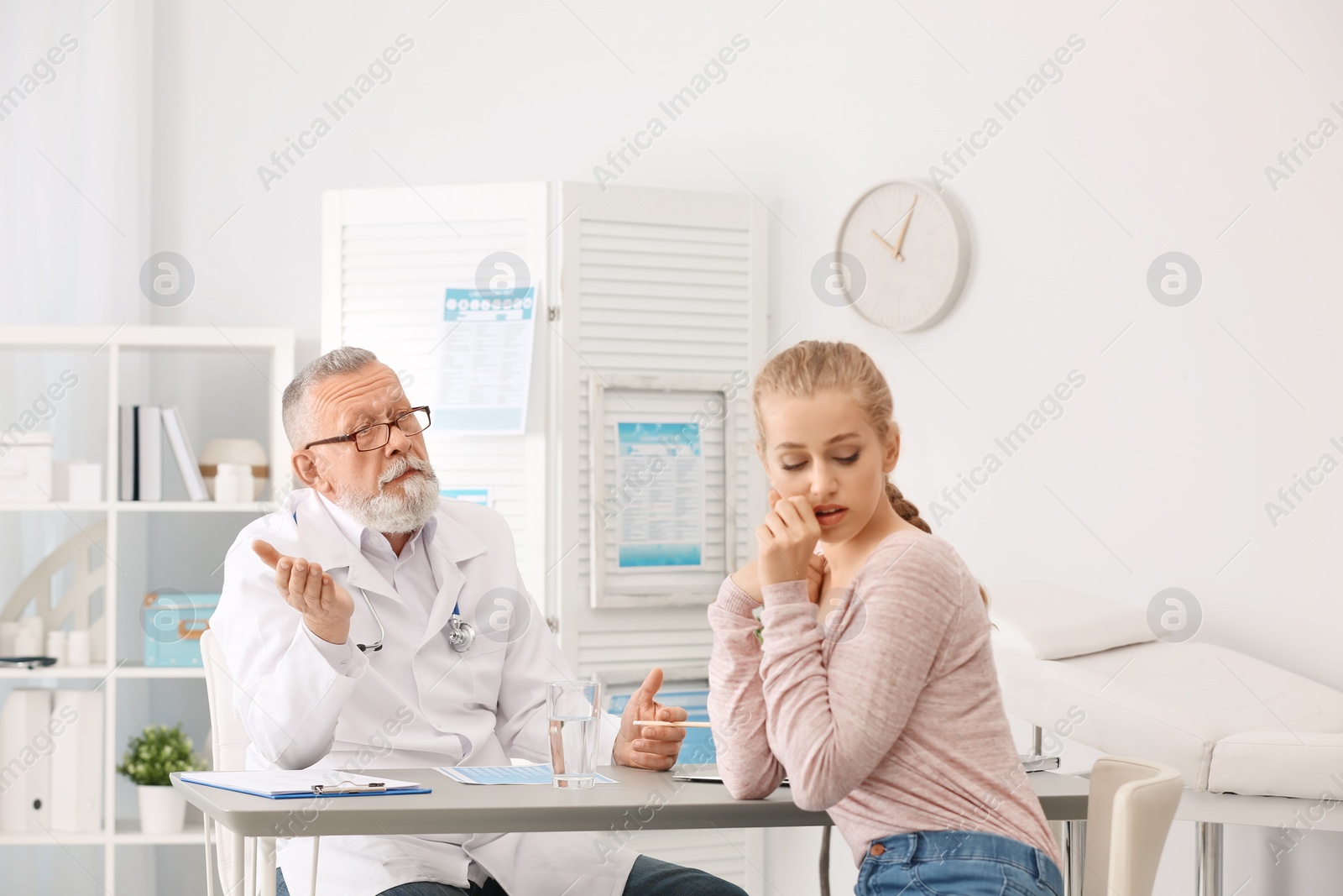 Photo of Coughing young woman visiting doctor at clinic