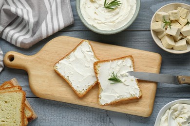 Photo of Delicious toasts with tofu cream cheese and rosemary on grey wooden table, flat lay