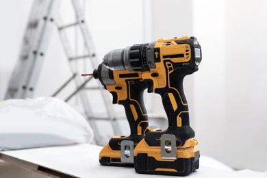 Pair of modern electric power drills indoors