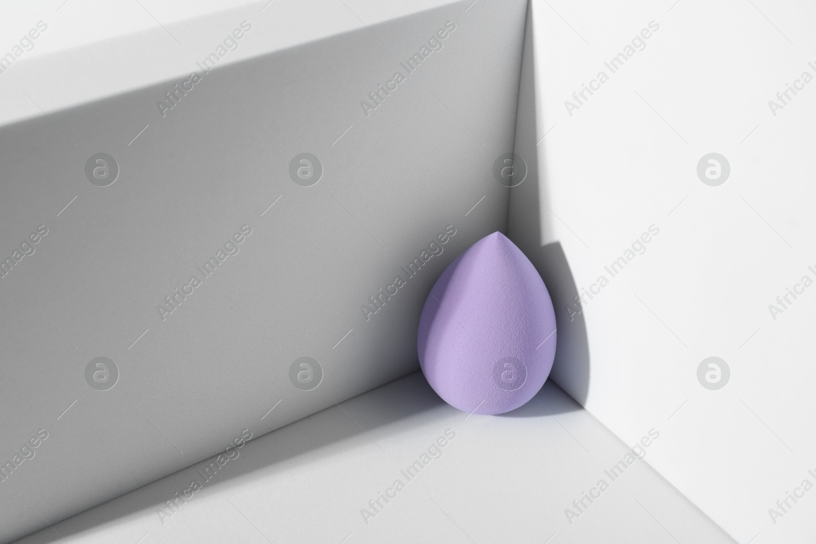 Photo of One violet makeup sponge on light background