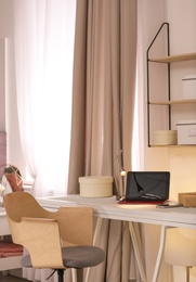 Photo of Workplace with laptop in stylish apartment. Room interior