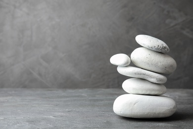 Stack of zen stones on table against grey background. Space for text