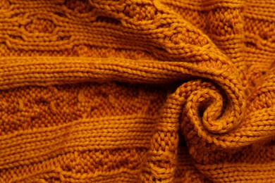 Photo of Beautiful orange knitted fabric as background, top view