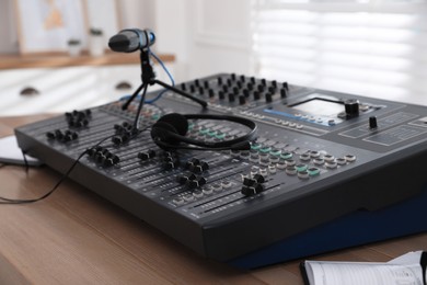 Photo of Professional audio equipment on wooden table in modern radio studio