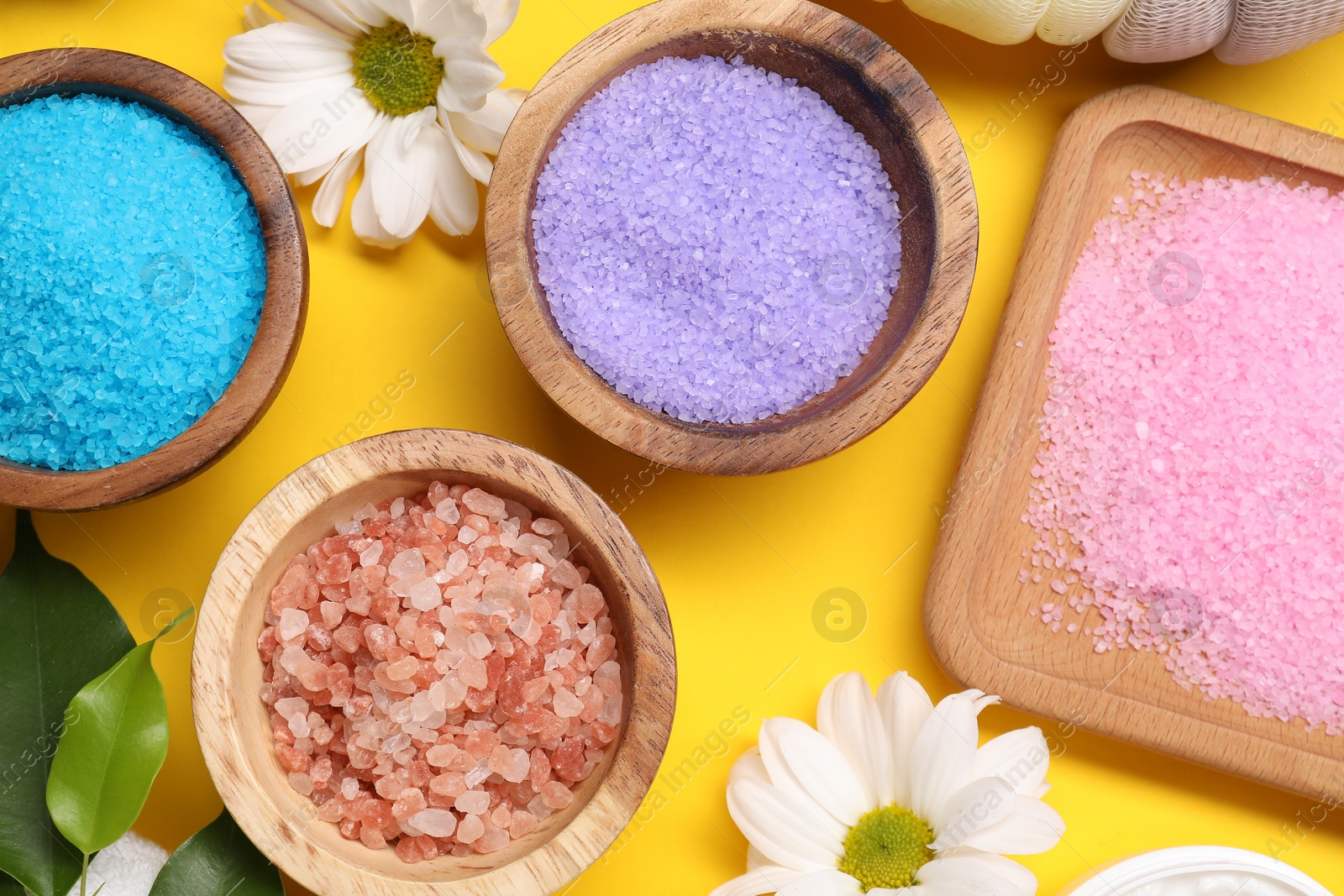 Photo of Flat lay composition with different sea salt on yellow background