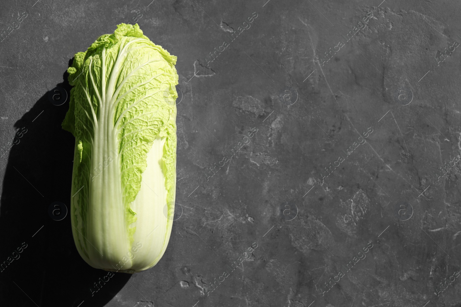 Photo of Fresh ripe Chinese cabbage on textured table, top view. Space for text