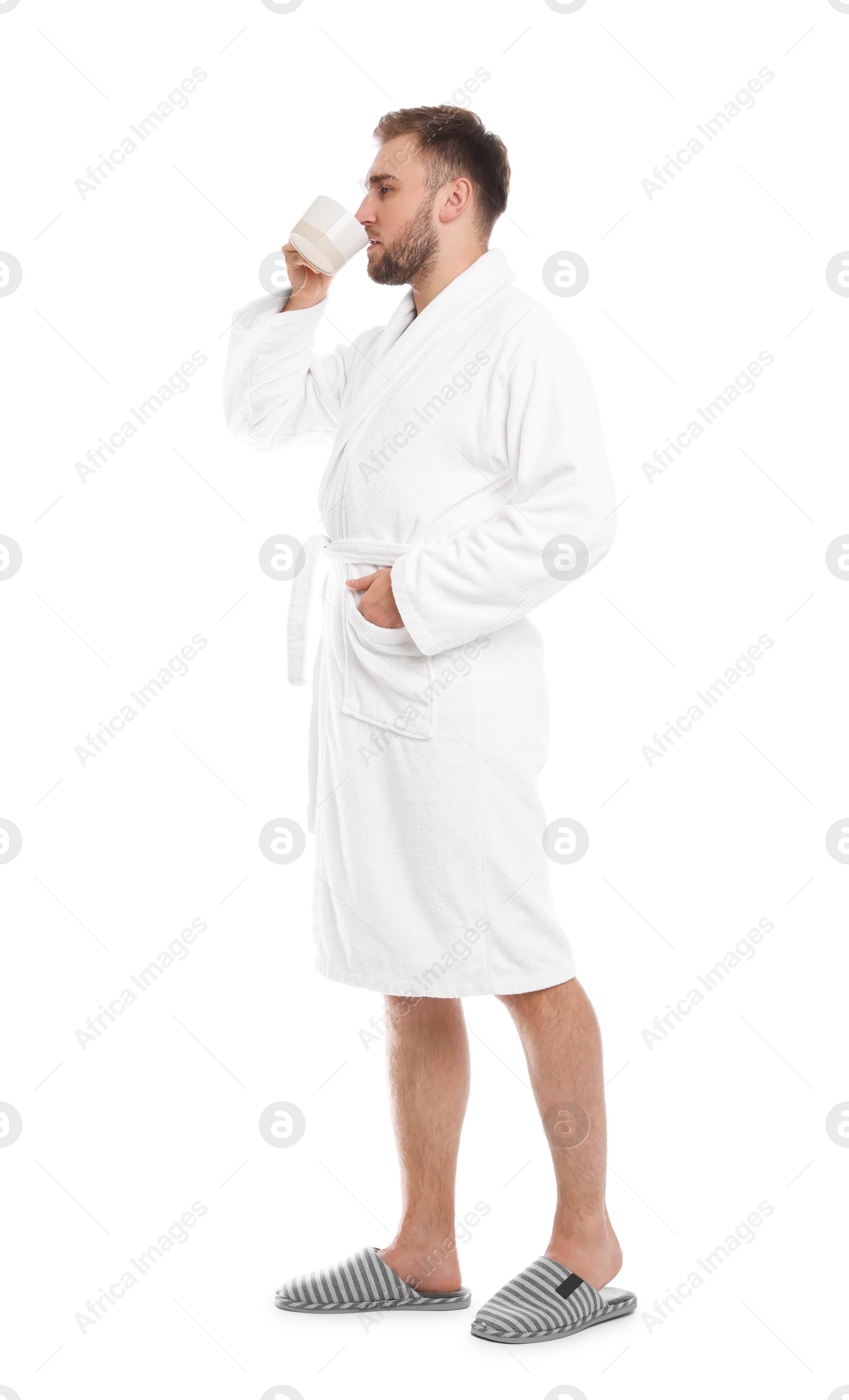 Photo of Handsome man in bathrobe with cup of coffee on white background