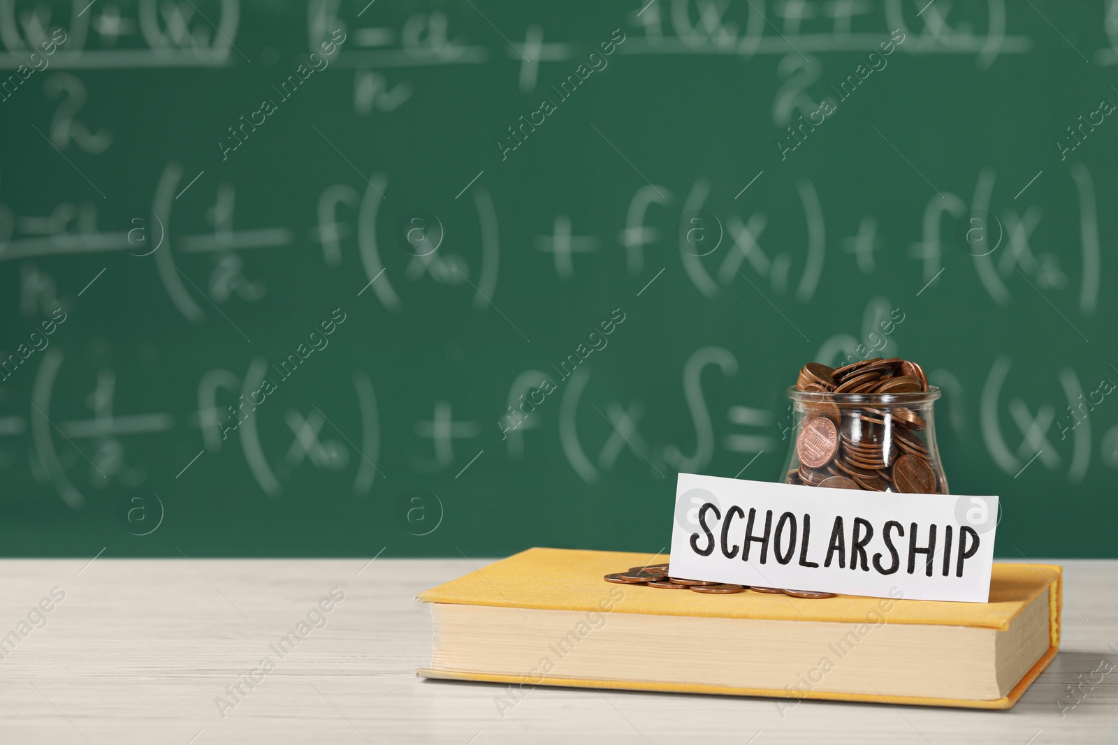 Photo of Scholarship concept. Sheet of paper, glass jar with coins and book on white wooden table, space for text