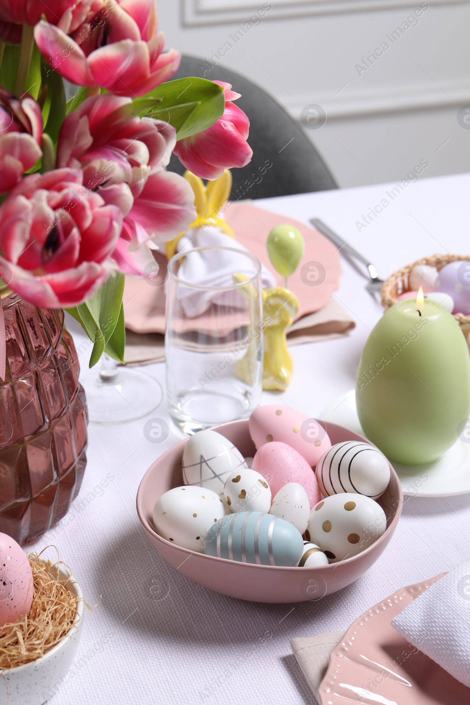 Photo of Festive table setting with painted eggs. Easter celebration