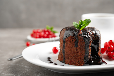 Photo of Delicious warm chocolate lava cake with mint and berries on marble table, closeup. Space for text