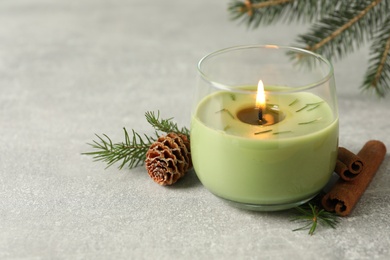 Photo of Composition with burning candle and pinecone on light grey table, space for text