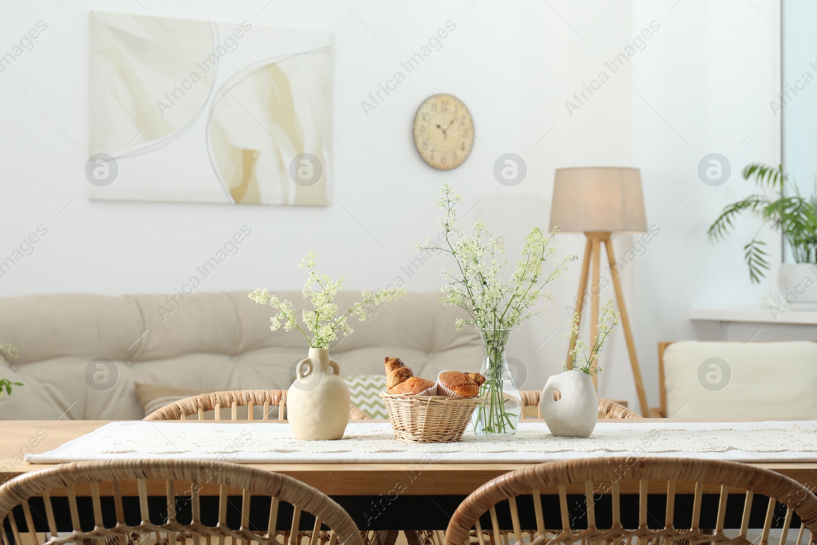 Photo of Fresh pastries and beautiful flowers on table in stylish dining room