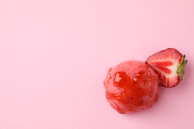 Photo of Scoop of delicious strawberry ice cream with syrup and fresh berry on pink background, top view. Space for text
