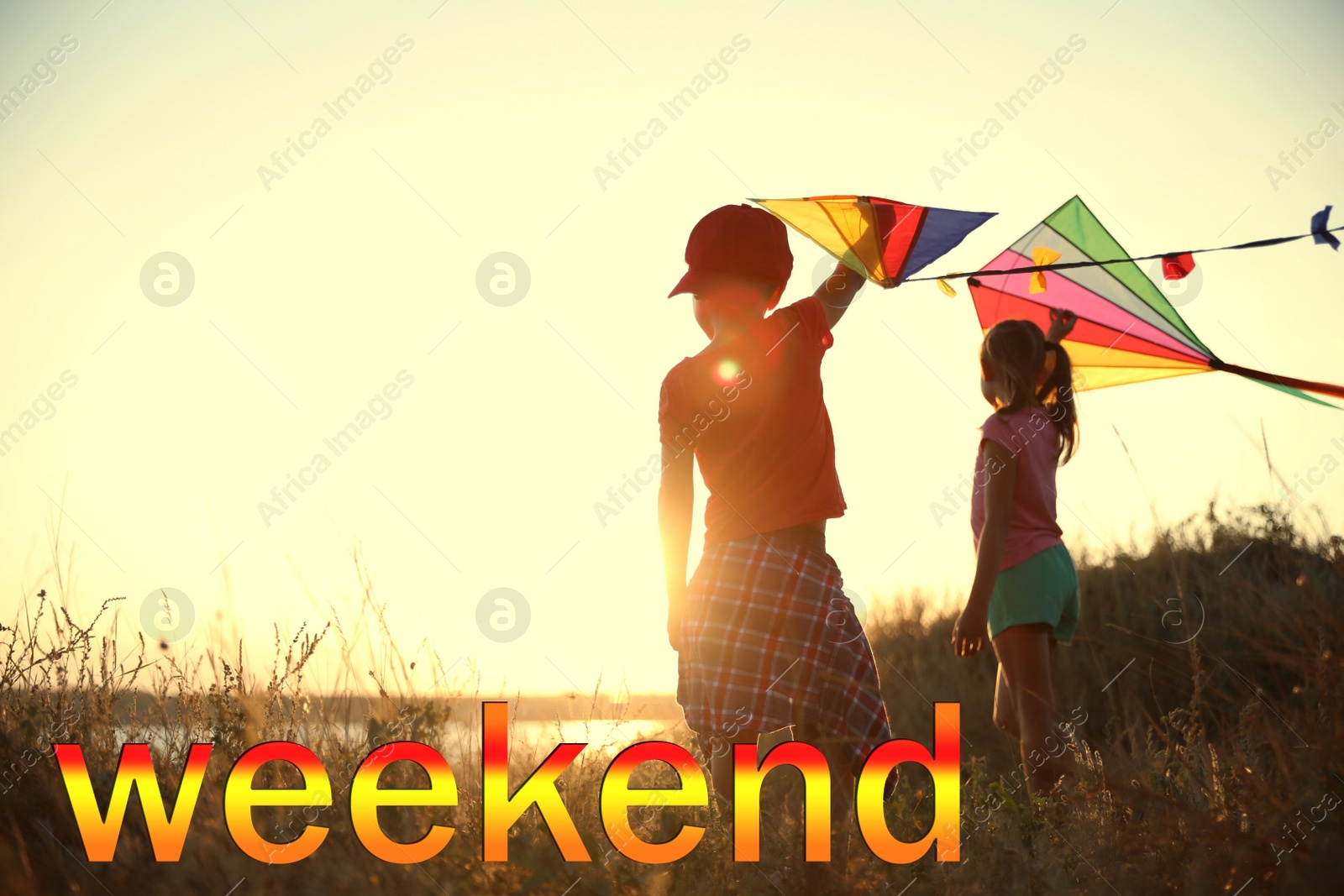 Image of Hello Weekend. Little children playing with kites outdoors at sunset