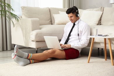 Photo of Businessman in shirt and underwear working on laptop at home