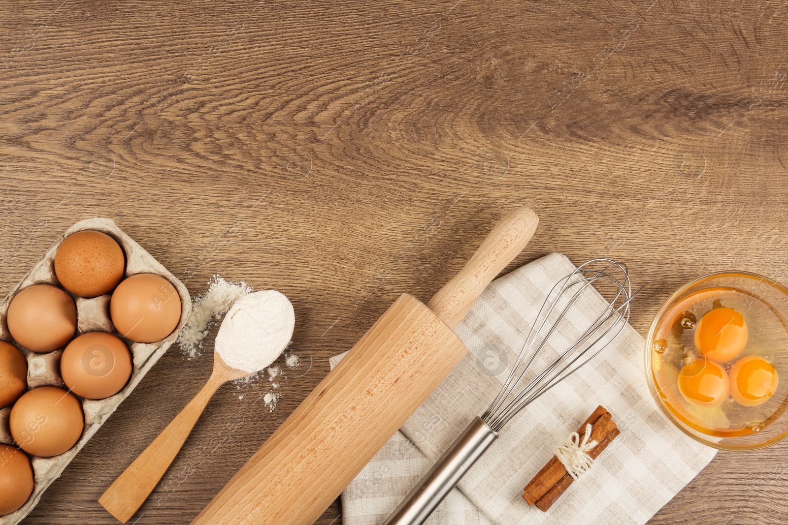 Photo of Flat lay composition with raw eggs and other ingredients on wooden background, space for text. Baking pie