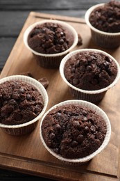 Photo of Board with delicious chocolate muffins on table, closeup