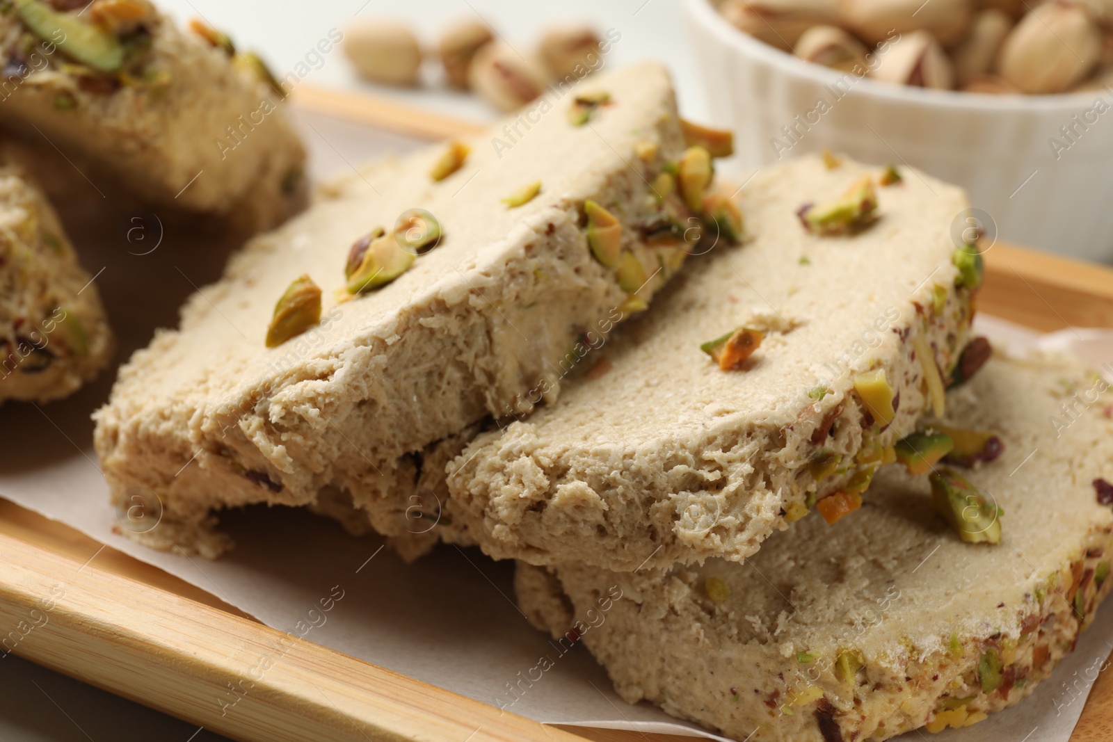 Photo of Tasty halva with pistachios on table, closeup